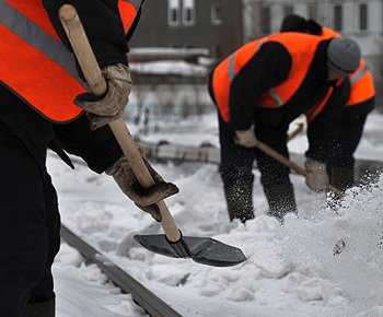 Бригада компании чистит снег во дворе дома
